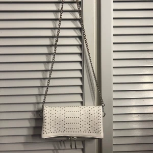 Vit axelväska med nitar - Snygg vit axelväska med silverfärgade nitar och kedja.
