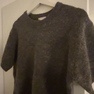 Stickad t shirt  - Säljer en mysig stickad mörkbrun tröja med korta ärmar. Perfekt för kyligare dagar och lätt att matcha med olika outfits. Är i st 170 men sitter som en S.