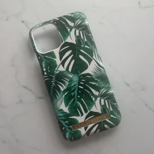 Mobilskal från iDeal of Sweden - Snyggt mobilskal från iDeal of Sweden med ett tropiskt bladmönster i grönt och vit. Oanvänt då jag beställde fel storlek så inga defekter. Skriv innan du köper eller bara har någon fråga💗