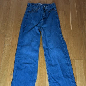 Blå jeans från 157 - Säljer ett par klassiska blå jeans från 157. De har en dragkedja och knapp framtill samt fem fickor. Perfekta för en avslappnad stil.