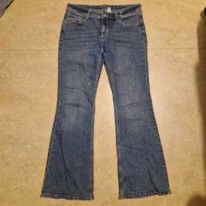 Blå bootcut jeans från Devided H&M - Blå lowwaist botcut jeans med vita sömar från H&M. Använt ett fåtal gånger för att den har en fläck på benet annars är den som ny! Måtten är: midja=80cm, inerbenlängd=79cm, längd=100cm, midjehöjd=21cm. Köptes för 299 nya. Pris kan diskuteras! Skriv om du vill ha flera bilder eller vill veta något annat!
