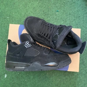 Black cats Jordan - Snygga svarta Nike Air Jordans i mocka med klassisk design och snörning. Perfekta för en stilren look.