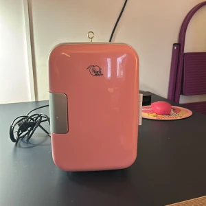 Rosa minikylskåp/ mini fridge  - nästan aldrig använd, bra för hudvård och smink. Kan både kyla och värma. Temperatur: 4°C till 40°C, Med praktisk (borttagbar) hylla och dörrficka, Förlänger hållbarheten på dina skönhetsprodukter, Med praktiskt bärhandtag, så att du kan ta med dig ditt Beauty-kylskåp överallt. 25x18cm