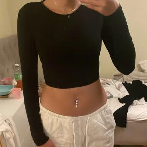 Fin svart långärmad topp - En fin svart basic långärmad topp ifrån Nelly i bra skick och i storlek XXS.