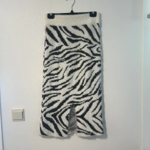 Zebramönstrad kjol med slits - Säljer en supercool zebramönstrad kjol i svart och vit. Kjolen är lång och har en snygg slits framtill som ger den en extra edge. Den är fluffig eller vad man säger man ser på bild 3. Endast testad på aldrig använd utöver det💕