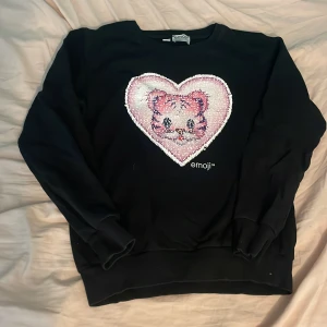 Svart Paljett tröja  - En svart tröja med paljetter på som bildar en bild på en tiger men som kan ändras till en enhörning. Knappt använd. Storlek 152/158.