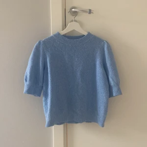 Ljusblå stickad tröja från Vero Moda - Säljer en superfin ljusblå stickad tröja från Vero Moda. Den har en normal passform med trekvartsärmar och en rund halsringning. Perfekt för vår och höst när det är lite kyligt ute. Tröjan är i bra begagnat skick och väldigt mjuk och skön att ha på sig. Passar både till jeans och kjol!