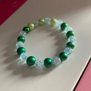 Färgglatt pärlarmband - Säljer ett Handgjort supercoolt armband med gröna, ljusgröna och genomskinliga pärlor. Perfekt för att liva upp vilken outfit som helst! Armbandet är elastiskt och passar de flesta handleder. Perfekt för både vardag och fest! 🌟