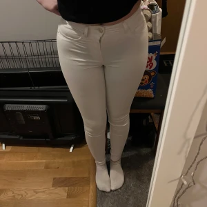 Vita skinny jeans - Snygga vita skinny jeans med hög midja och klassisk femficksdesign. Perfekta för en stilren look. De har en dragkedja och knapp framtill. Midjemått: ca 31cm                                      Innerbensmått: 72cm