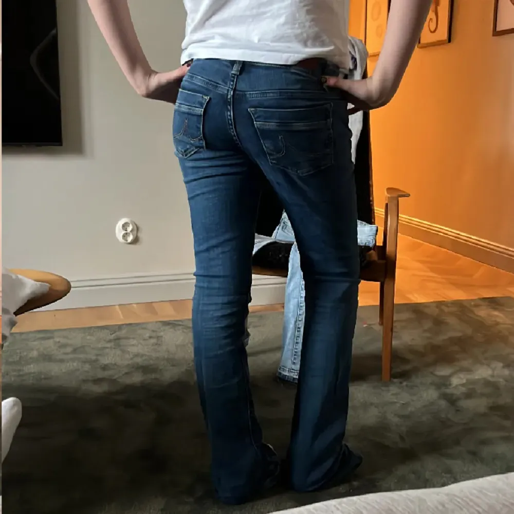 Snygga mörkblå bootcut jeans från LTB, i storlek W24/L34. Jeansen har låg midja och är i ett stretchigt material. Använda få gånger, inga defekter. Nypris 800 kr. Minjemåttet är ca 78 och innerbenslängden är ca 85💞Liten defekt vid kanten i midjan, se sista bilden.💞. Farkut & Housut.