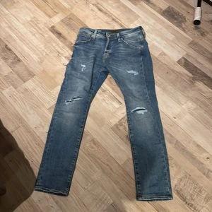 Blå jeans med slitningar - Ett par slim fit Jack and Jones jeans med slitningar😮‍💨köpte dem för 799 kr och använt dem typ 2 ggr nytt pris 799kr mitt pris 459kr