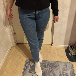 Blå jeans från Gina Tricot - Snygga blå jeans från Gina Tricot med en tight passform. De är högmidjade och har en klassisk femficksdesign. Perfekta för en stilren look.