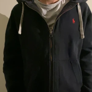 Svart zip hoodie från Ralph Lauren - Säljer en riktigt snygg zip hoodie från Ralph lauren.        Modellen är 174 men den passar någon som är lite större också. Den har ett bra men använt skick.