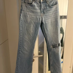 Ljusblå jeans från Gina - Snygga ljusblå jeans med slitningar på benen från Gina. De har en klassisk femficksdesign och en bekväm passform. Perfekta för en avslappnad stil.