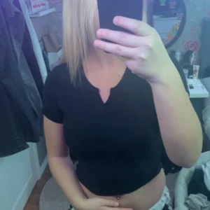 Svart croppad topp - Säljer en stilren svart croppad topp med korta ärmar. 