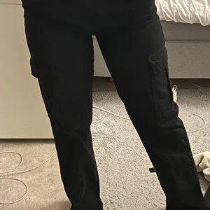 Svarta cargobyxor - säljer mina snygga svarta cargobyxor med flera praktiska fickor från stradivarius då de ej kommer till användning. Byxorna har en normal passform och är ett bekvämt material. De är lite långa på mig som är 157cm.