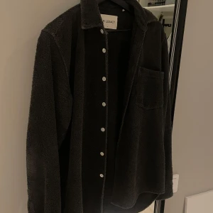 Svart skjorta från Our Legacy - Säljer en stilren svart skjorta från Our Legacy i 100% bomull. Skjortan har långa ärmar och knappar framtill. Perfekt för en avslappnad men ändå elegant look. 🖤