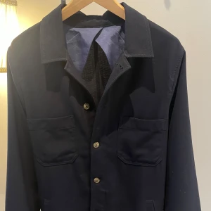 Mörkblå Overshirt  från Sand Copenhagen Nypris 1699kr. - Säljer en stilren mörkblå jacka från Sand Copenhagen. Jackan har en klassisk krage och knappar framtill. Den är långärmad och har två bröstfickor. Perfekt för en elegant look.