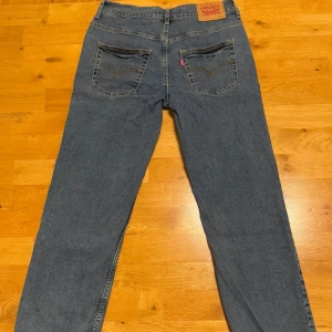 Levi's 551 Z Authentic Straight Jeans - Hej! Säljer ett par klassiska Levi's 551 Z Authentic Straight jeans i blå denim. De har en rak passform och är tillverkade i mjukt jeansmaterial.