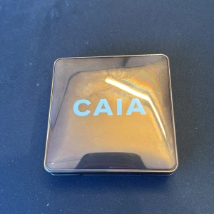 Glow Bronzer från CAIA La Digue - Snygg bronzer från CAIA i en elegant fyrkantig förpackning med spegel. Perfekt för att ge ansiktet en solkysst look med en fin glöd. Kompakt design som är lätt att ta med i väskan. Färgen är La Digue. Sälj pga felköp till dotter i present