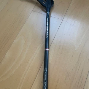 Svart innebandyklubba från Fat Pipe - Säljer en svart innebandyklubba från Fat Pipe med texten 'G27' och '2.6' på skaftet. Klubban har ett svart blad och ett greppvänligt handtag. Perfekt för innebandyentusiaster som vill ha bra kontroll och precision på planen.