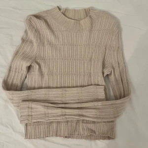 Beige ribbad tröja - Säljer en stilren beige ribbad tröja med långa ärmar. 