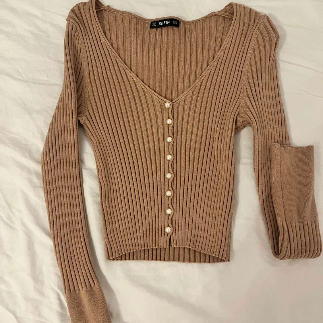 Beige ribbad kofta pärlknappar