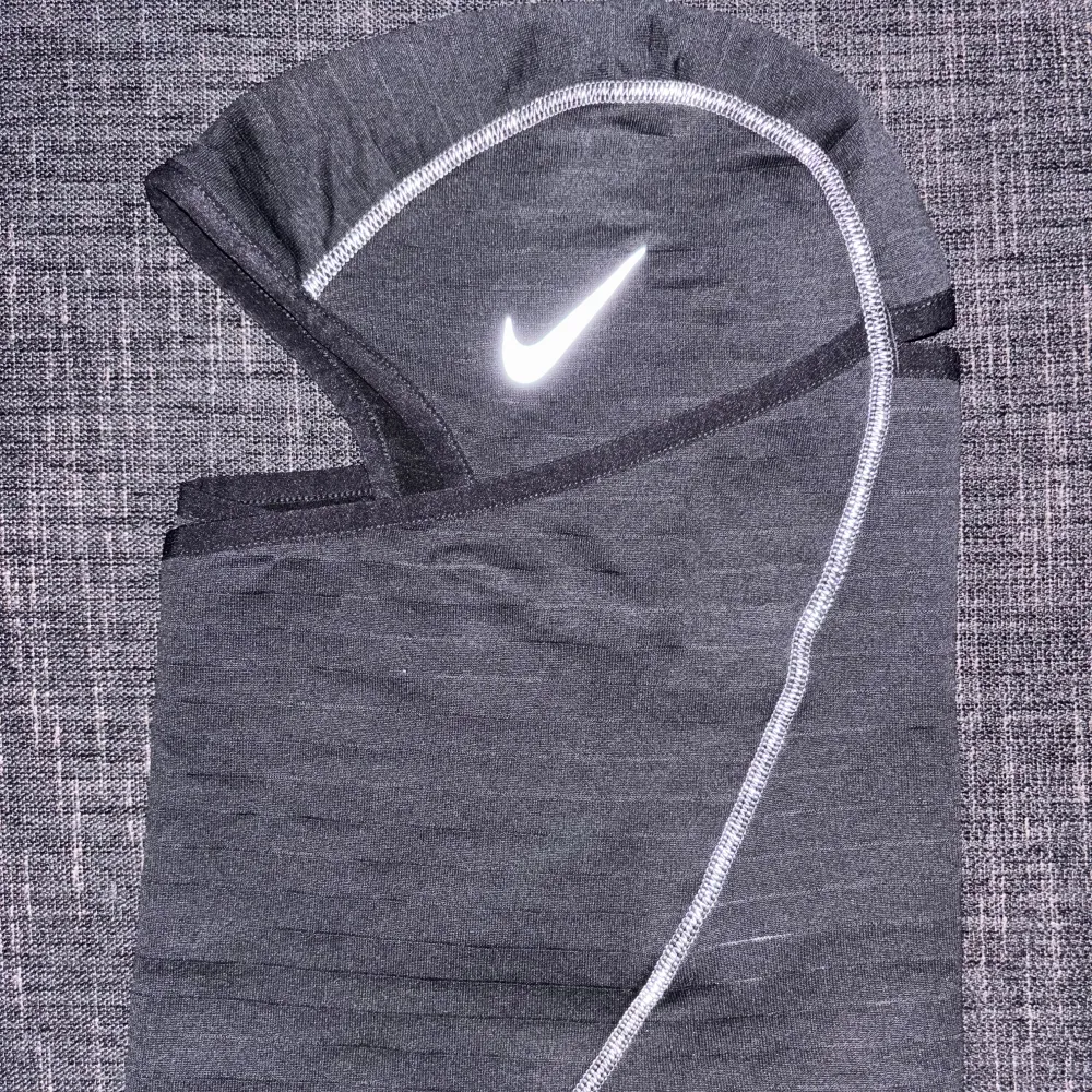 Snygg och funktionell balaclava från Nike, perfekt för kalla dagar. Den är tillverkad i ett mjukt och stretchigt material med reflex sömmar och har en Nike-logga som också är reflex framtill. Passar bra för utomhusaktiviteter som löpning eller cykling under höst och vinter.. Accessoarer.