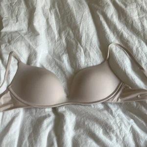 Beige bh - Säljer en stilren beige bh i mycket bra skick från intimismi. Det är den populära push-up bh-n. Den är aldrig använd då den är för liten dock är alla etiketter avklippta. Den har justerbara axelband och en slät yta som gör den perfekt under tighta kläder. Bekväm och diskret för vardagsbruk💗(kan gå ner i pris)