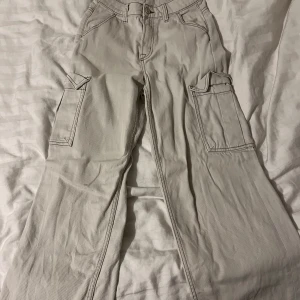 Beige cargobyxor från H&M Divided - Säljer ett par snygga beige cargobyxor från H&M Divided i storlek 32. Byxorna har en loose passform med praktiska fickor på sidorna och en hög midja. Perfekta för en avslappnad stil och passar bra till både vardag och fest. 👜✨. SKRIV OM PRISFÖRSLAG 