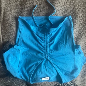 Blå halterneck topp helt oanvänd💕 - Snygg blå halterneck topp! Tppen har en cool snörning framtill som ger en unik look. Perfekt för sommarens fester eller en dag på stan. Passar bra till både jeans och kjol!🩷🩷pris går att diskutera