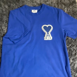 Ami t shirt - Säljer en snygg blå t-shirt från Ami. T-shirten är i bra skick och gjord av mjuk bomull. Passar perfekt till både jeans och shorts! Storlek s.
