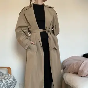 Säljer en klassisk beige trenchcoat i mycket bra skick. Den har ett bälte i midjan och knappar framtill. Perfekt för höst och vår, med långa ärmar och en stilren design. Passar både till vardags och lite finare tillfällen. Passar XS-M.