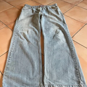 Ljusblå jeansbyxor - Säljer ett par ljusblå vintagejeans från strom i loose fit. De har en avslappnad stil med breda ben och är perfekta för en chill vardagslook. Byxorna är i rätt schysst skick. Size on tag är W36 L32, men sitter som en W33 L32 ca