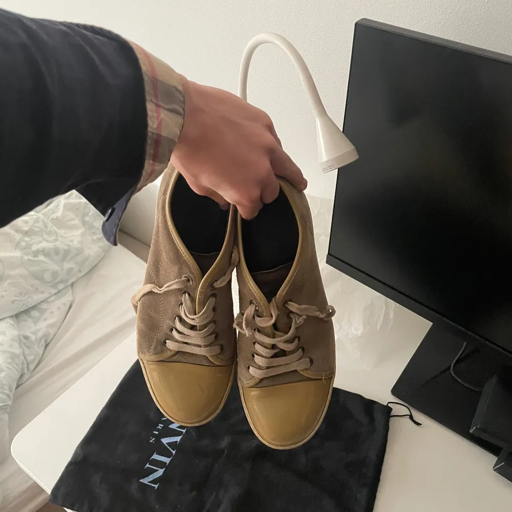 Säljer ett par beige sneakers från lanvin. De har en cool vintage-look och är perfekta för vardagsbruk. Skorna är i bra skick. Perfekt för höst och vår!. Skor.