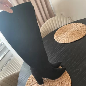 Svarta stövlar med klack - Snygga svarta stövlar i mocka med hög klack och spetsig tå. I fint skick då de endast kommit till en användning förra hösten. Storlek 38