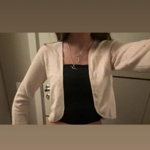 Ljusrosa glittrig kofta - Säljer en superfin ljusrosa kofta med glittriga detaljer. Perfekt för att piffa upp en outfit! Den är långärmad och har en öppen design som gör den lätt att matcha med olika toppar. Perfekt för både vardag och fest. 🥳