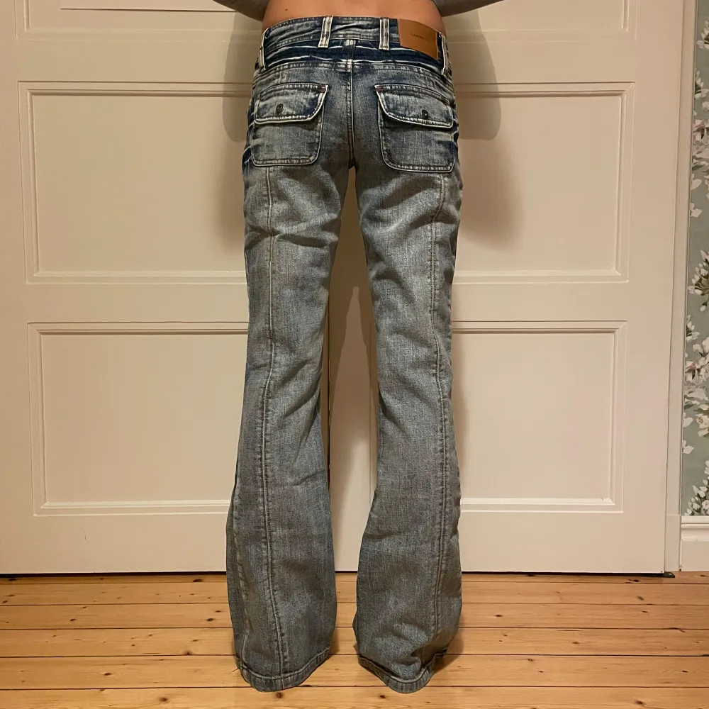 Säljer ett par snygga lågmidjade bootcut jeans från Casting. De är i en klassisk blå denim med coola detaljer som fickor med knappar bak. Bra skick! . Jeans & Byxor.