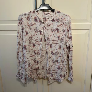 Mönstrad blus fån lindex - Söt mönstrad blus från Lindex i strl L men passar bra på M med. Super söta färger och fin guld knapp högst upp. 