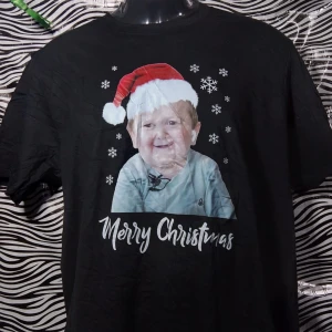 Svart jultröja med tryck - Säljer en svart t-shirt med ett roligt julmotiv. Den har en bild av ett barn med tomteluva och texten 'Merry Christmas'. Perfekt för julfesten eller som en kul present! 🎅