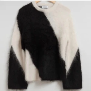 Svart och vit fluffig tröja från and other storis  - Säljer en supermjuk och fluffig tröja från and other storis i svart och vitt. Den har ett coolt diagonalt mönster och är perfekt för kyliga dagar. Tröjan är långärmad och har en avslappnad passform. Perfekt för både vardag och mysiga hemmakvällar! 