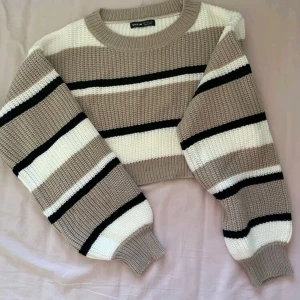 Beige och svart randig stickad tröja från Shein - Säljer en superfin stickad tröja från Shein i beige, svart och vitt. Den är croppad och har långa ärmar med breda ränder. Perfekt för höst och vår när du vill vara både stilren och bekväm. Passar perfekt till ett par jeans eller kjol!