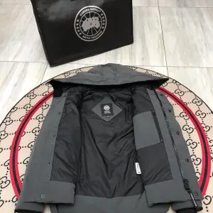 Säljer en snygg grå dunjacka från Canada Goose. Jackan har en stilren design med huva och dragkedja. Perfekt för kalla vinterdagar. Den är i mycket bra skick och håller dig varm och bekväm. Passar både till vardags och lite finare tillfällen. Den är köpt 2024/10/29 men nu har jag köpt en burberry istället så vill sälja den den är i storlek M men passar även S, köpare står för frakten