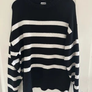 Svart och vit randig stickad tröja  - Säljer en superfin randig tröja i storlek S. Slits i sidan och mudd i kanterna. Använd fåtal gånger. Mycket fint skick!💗