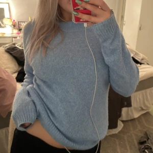 Ljusblå stickad tröja - Mysig ljusblå stickad tröja i mjukt material. Perfekt för kyliga dagar med sin avslappnade passform och långa ärmar. Ribbstickade muddar vid ärmslut och nederkant ger en klassisk look. Passar både till vardags och mysiga hemmakvällar. 🧶💙 Aldrig använd 