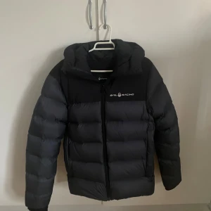 Svart dunjacka från Sail Racing - Snygg och varm svart dunjacka från Sail Racing. Sparsamt använd utan några skador. Perfekt för kyliga dagar. Säljer då den blivit för liten. Hör gärna av er om ni har frågor!