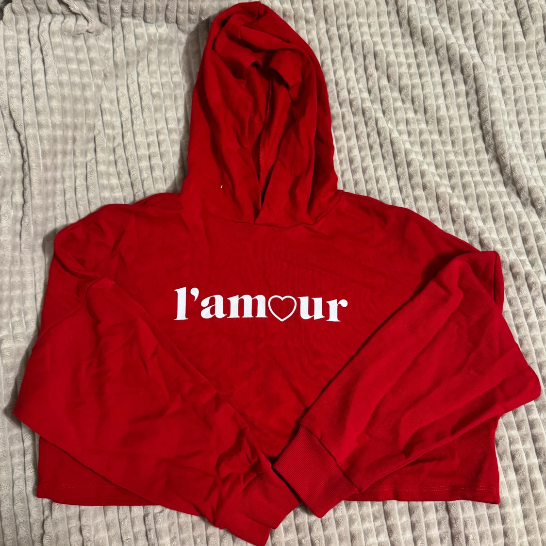 Röd hoodie med texten 'l'amour'