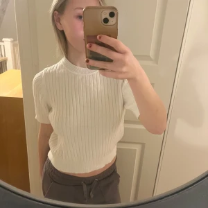 Vit ribbad stickad tshirt - Säljer en stilren vit ribbad tshirt med korta ärmar. 