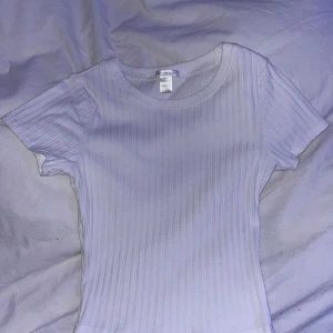 Vit ribbad topp från Bozzolo - Säljer en vit ribbad topp från Bozzolo i storlek S. Toppen har korta ärmar och en rund halsringning.