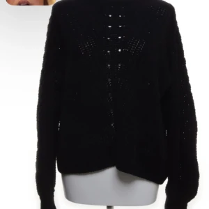 Svart stickad tröja - Säljer en svart stickad tröja med långärmad design. Tröjan har ett diskret hålmönster framtill som ger en snygg detalj. Perfekt för kyligare dagar.